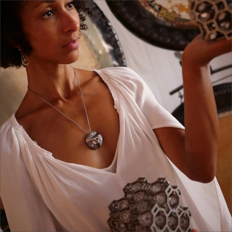 Woman in white blouse wearing an ARK crystal necklace